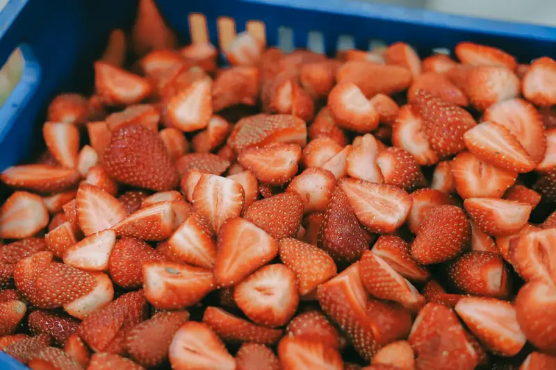 Frozen strawberries in a carton lined with blue plastic