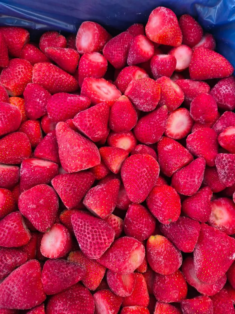 Frosted whole IQF strawberries in a blue-lined export carton